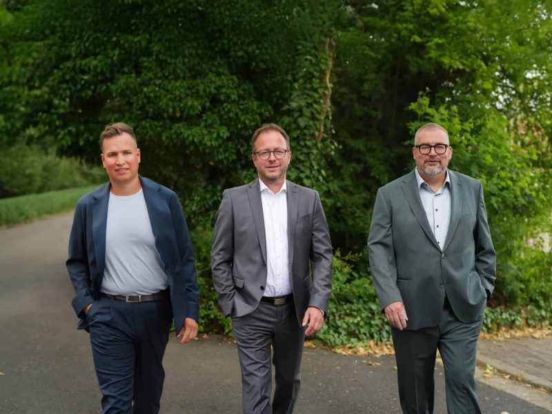 Drei Geschäftsleute gehen gemeinsam im Grünen